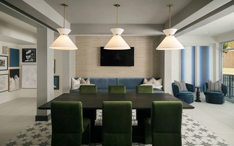 A modern dining room with a dark table and green chairs.