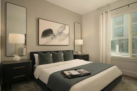 A bedroom with a large bed, two lamps, and a painting on the wall.