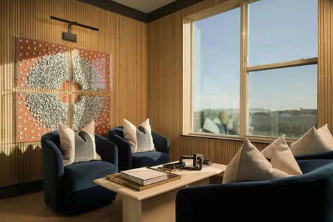 A living room with blue chairs and a table with a book on it.