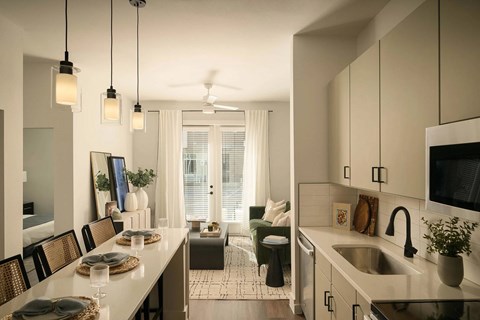 A modern kitchen with a dining table set for two.