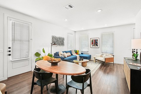 A modern living room with a dining table and chairs.