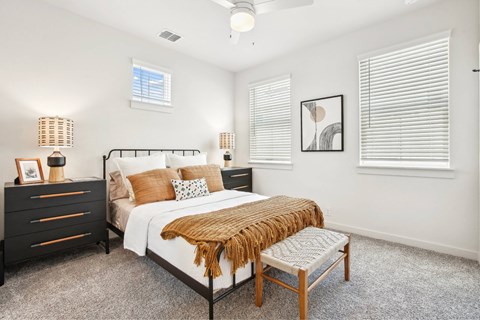 A bedroom with a bed, nightstand, and a chair.
