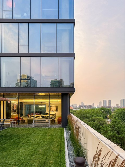 A modern glass building with a view of the city skyline.