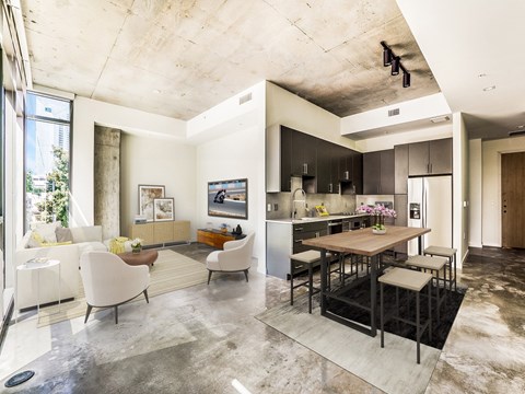 A modern open plan living and kitchen area with a dining table and chairs.