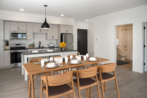 A modern kitchen with a dining table set for four.