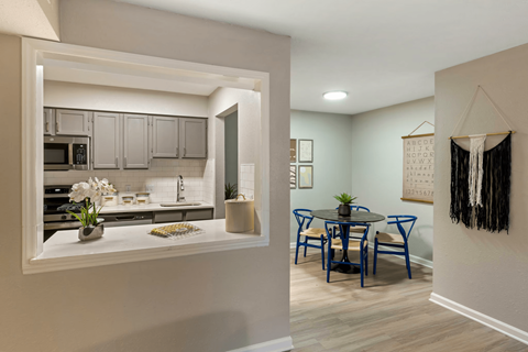 A kitchen with a dining table and chairs.