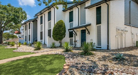 A white building with a green lawn in front.