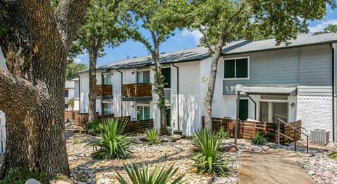 A row of houses with trees in front.