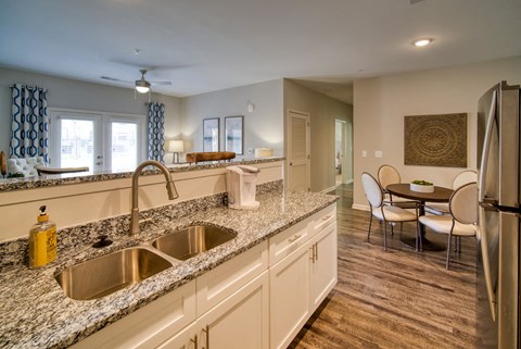 A kitchen with a sink and a refrigerator.