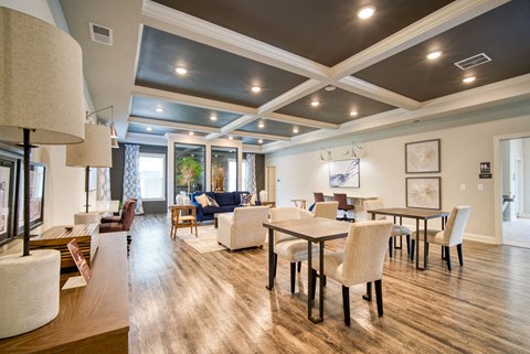 A well-lit, spacious dining room with a large table and chairs.