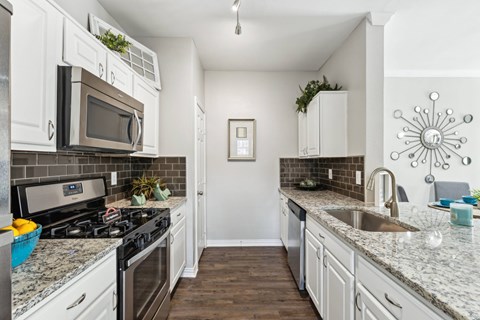 A kitchen with white cabinets at Towns at Chapel Hill in Plano Texas