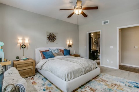 A bedroom with a large bed and a ceiling fan.