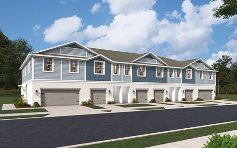 A blue and white house with a grey roof and white garage doors.