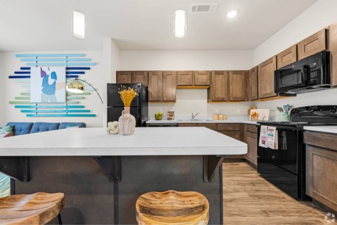 A kitchen with a white counter top and wooden cabinets.