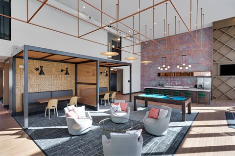 A modern living room with a pool table and a bar area.