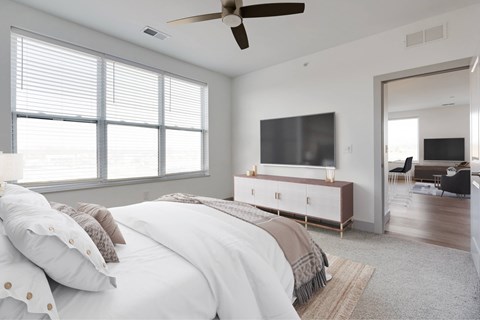 A bedroom with a large bed and a television in the corner.