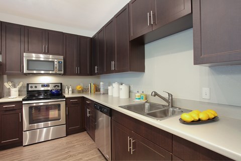 A kitchen with brown cabinets and stainless steel appliances.