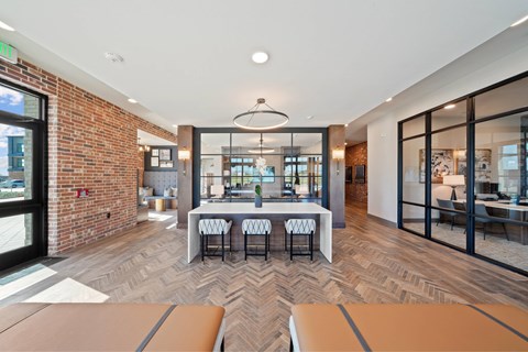 A modern office space with a brick wall and a long table with chairs.