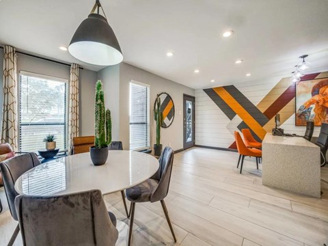A modern dining room with a white table and grey chairs.