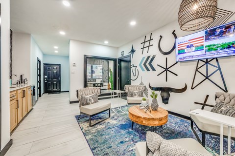 A modern living room with a blue rug and a television mounted on the wall.