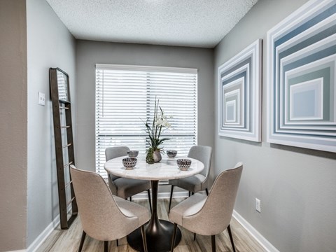 A dining room with a table and chairs.