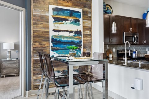 A modern kitchen with a glass table and chairs.