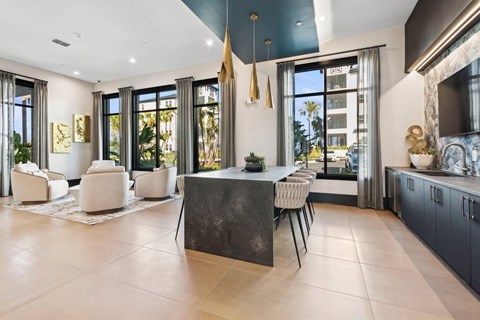 A modern kitchen with a large island and a dining area.