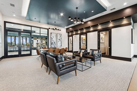 A spacious living room with a grey carpet and furniture.
