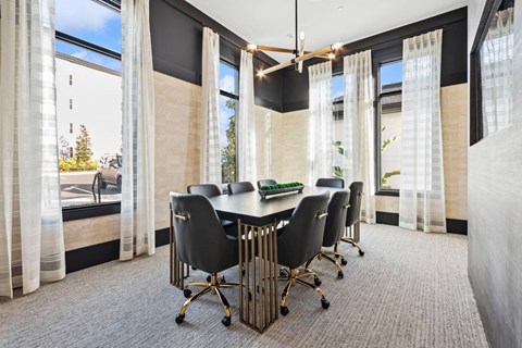 A conference room with a table surrounded by chairs.