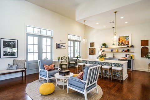 A living room with a blue chair and a yellow pouf.