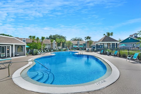 A large outdoor swimming pool with a white border and blue water.