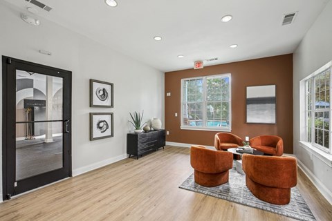 A living room with a brown sofa and two orange chairs.