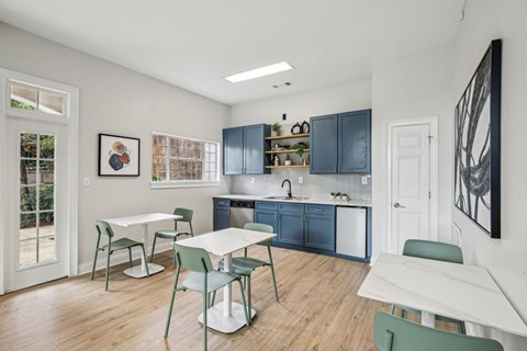 A kitchen with a table and chairs in front of a cabinet.