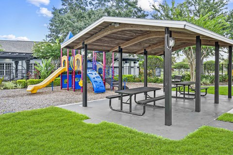 A playground with a slide and a picnic table.
