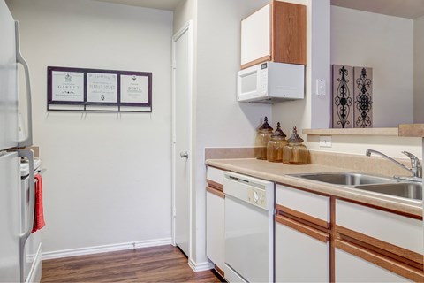 A kitchen with white appliances and wooden accents.