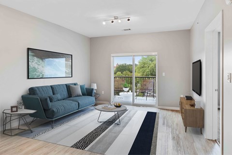 A living room with a blue couch and a painting on the wall.