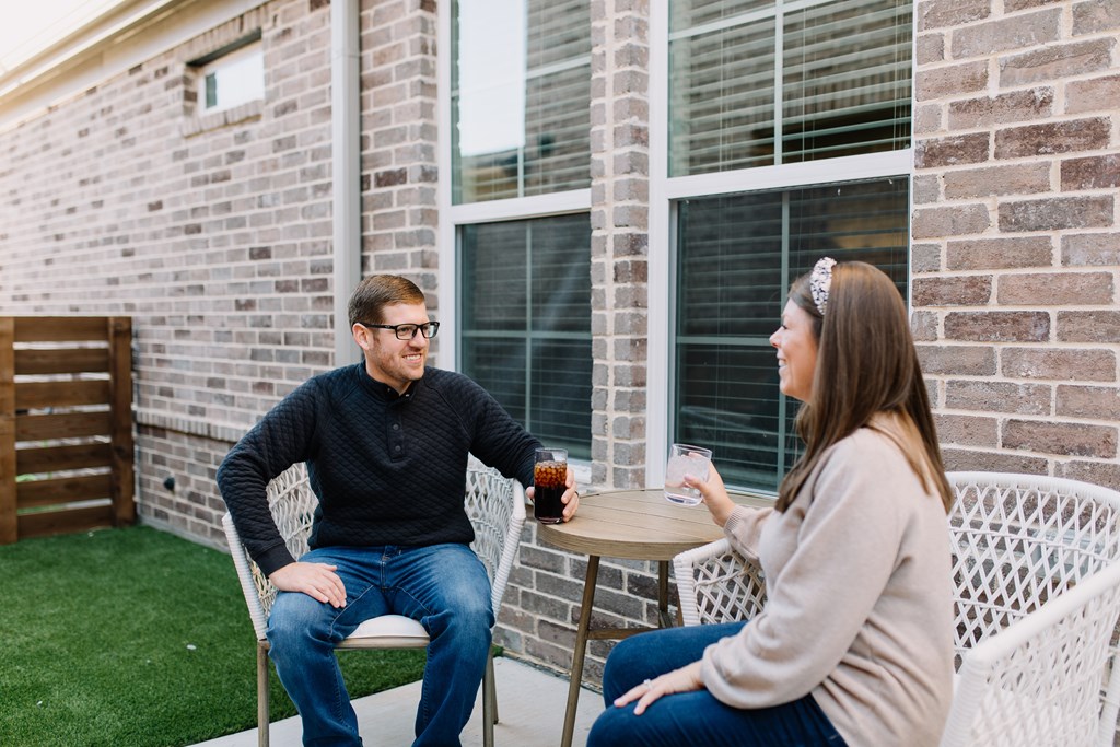 a man and a woman sitting at a table on a patio
