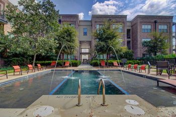a pool with chairs and a building in the background