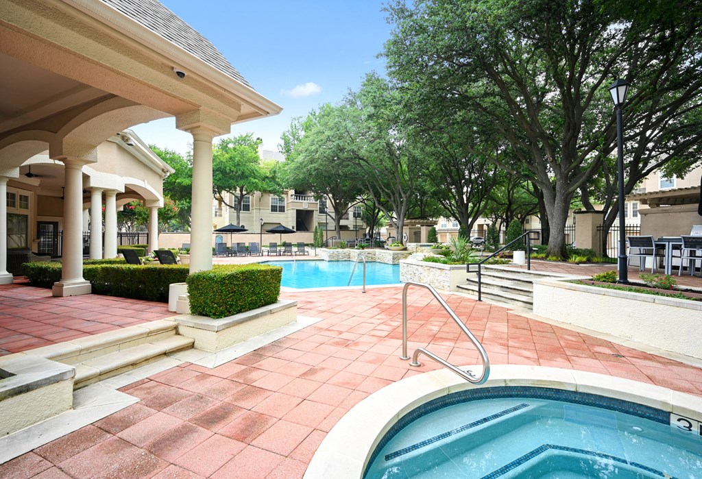 a swimming pool with a spa in front of a resort style pool