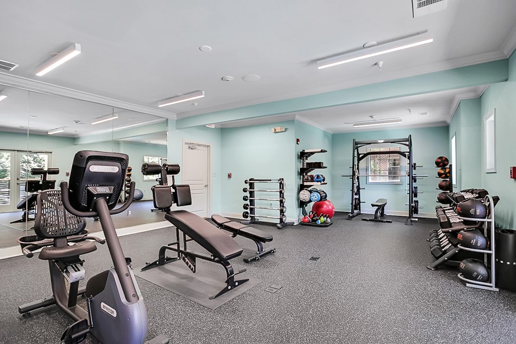 a gym with cardio equipment and weights in a building with blue walls