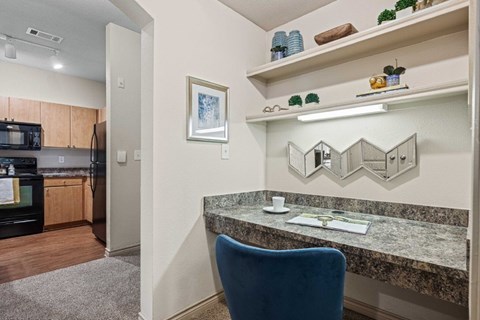 A kitchen with a blue chair and a marble counter.