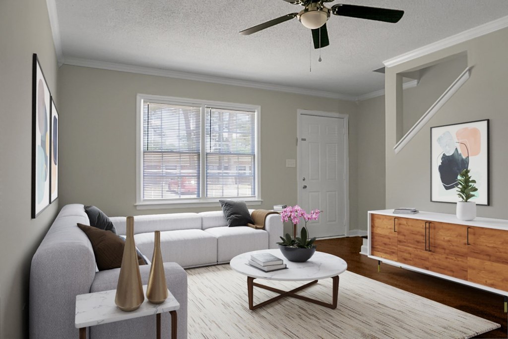 A living room with a grey sofa, a white coffee table, and a painting on the wall.