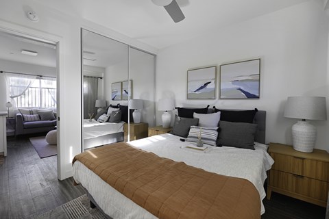 A bedroom with a large bed and a mirror on the wall.