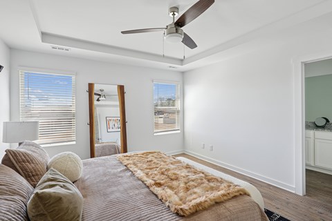 A bedroom with a large bed and a ceiling fan.