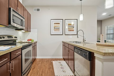 A kitchen with brown cabinets and a white dishwasher.