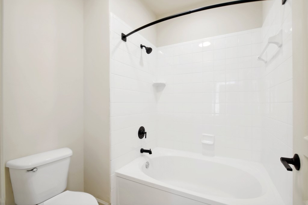 a white bathroom with a tub and a toilet