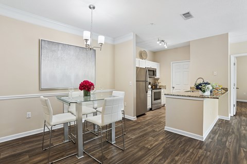 A dining room with a glass table and chairs.