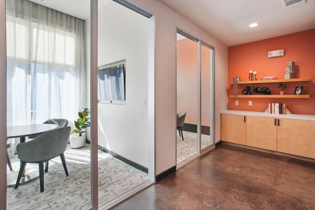a living room with orange walls and a table and a mirror