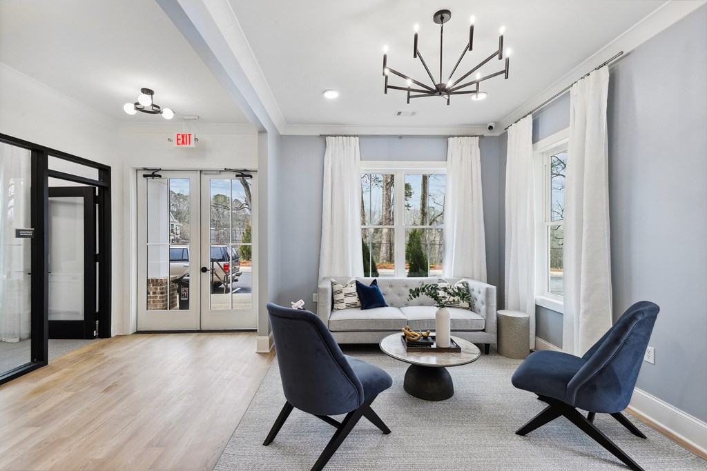 a living room with a couch and chairs and a chandelier