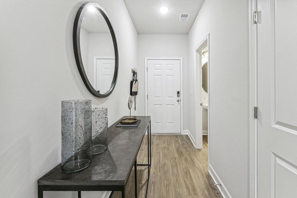 a hallway with a table and a mirror in a house